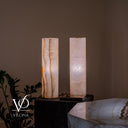 Illuminated reverse view of the White Ice onyx table lamps with one finely banded face and one clouded white face.