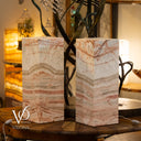 Two marble-patterned lamps on a wooden surface with blurred background