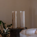 Unlit reverse view of two White Ice onyx cylinder lamps showing milky stone, soft honey veining, and polished surfaces.