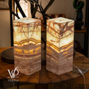 Two onyx table lamps on a wooden surface with a blurred background