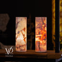 Two cylindrical lamps with a marbled pattern on a wooden surface, branded 'Vilona'.