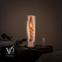 Illuminated 20-inch White Ice onyx cylinder table lamp with a dramatic amber mineral channel and pearl-white stone.