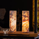 Two cylindrical lamps with a marbled pattern on a wooden surface, branded 'Vilona'.