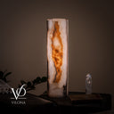 Close illuminated product view of the White Ice onyx lamp highlighting its glowing amber channel and crystalline white edges.