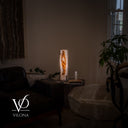 Wide room view showing the scale of the 20-inch White Ice onyx lamp beside a chair and natural stone coffee table.