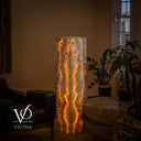 Illuminated second face of the Golden Cloud onyx tower lamp with symmetrical golden ribbons and intricate gray mineral banding.