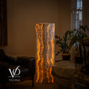 Illuminated third face of the square Golden Cloud onyx floor lamp with a dark central mineral spine and amber-gold waves.
