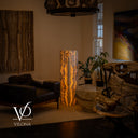 Wide interior view showing the scale of the 51-inch Golden Cloud onyx floor lamp among natural stone furnishings and artwork.