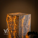 Close-up of the illuminated top corner of the Golden Cloud onyx floor lamp showing continuous banding across two sides and the polished top.