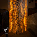 Close-up of the lower Golden Cloud onyx floor lamp showing dense amber illumination and intricate charcoal mineral contours.