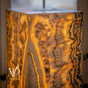 Detailed illuminated view of the upper Golden Cloud onyx formation with crystalline pockets, golden ribbons, and dark lace-like bands.