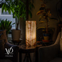 Bamboo Onyx table lamp Light Edition #1 glowing warmly on a luxury stone table