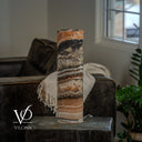Polished Tangerine Onyx cylinder lamp switched off, revealing a broad charcoal band above ivory, peach, and tan layers.
