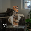 Unlit side view of a Tangerine Onyx cylinder lamp showing diagonal peach banding, cream crystals, and charcoal layers.
