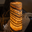 Close-up of a glowing Tangerine Onyx lamp showing its polished open rim, golden crystals, and dark mineral banding.