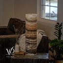Unlit cord-side view of a Tangerine Onyx lamp with ivory, peach, and brown layers and a white cord crossing the lower front.