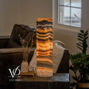 Glowing Tangerine Onyx table lamp with curved amber crystals, narrow orange ribbons, and a pale cream base.