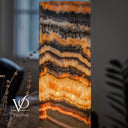 Close-up of illuminated Tangerine Onyx showing branching dark mineral patterns, broad golden crystals, and orange seams.