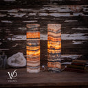 Glowing Tangerine Onyx lamp pair with an orange upper band on the left lamp and a golden center on the right.