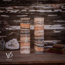 Unlit rear view of a Tangerine Onyx lamp pair showing peach, cream, and charcoal layers with cords at the bases.