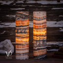 Closer illuminated view of the Tangerine Onyx lamp pair showing golden crystal formations and contrasting dark bands.