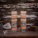 Unlit Tangerine Onyx table lamp pair showing peach, ivory and charcoal bands across smooth polished cylinders.