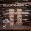 Unlit Tangerine Onyx cylinder lamps showing a diagonal ivory vein on the left and curved cream banding on the right.