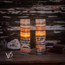 Rear view of illuminated Tangerine Onyx cylinder lamps, showing arched stone patterns and cord exits near the bases.