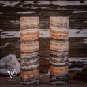 Closer view of unlit Tangerine Onyx cylinder lamps, showing fine peach and ivory layers above dark mottled bands.