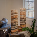 Unlit Tangerine Onyx lamp pair beside a window, showing ivory, apricot and charcoal bands on the foreground lamp.