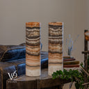 Unlit Tangerine Onyx cylinder lamps with charcoal and brown upper bands, peach layers and creamy ivory bases.