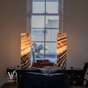 Rotated view of illuminated Tangerine Onyx lamps with glowing cream centers and charcoal bands rising diagonally to the right.