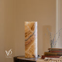 Matching unlit side view of an Aqua Onyx lamp with diagonal cream, honey, gray, and muted rose bands beneath an irregular rim.