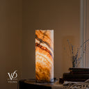 Illuminated Aqua Onyx lamp with dark-edged bands sweeping downward to the right above broad golden crystal formations.