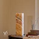 Unlit Aqua Onyx lamp with diagonal gray and rose banding across cream and honey stone, showing its irregular top edge.