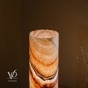 Close detail of the illuminated Aqua Onyx lamp’s open live-edge rim, showing its interior, cream crystal texture, and curved amber bands.