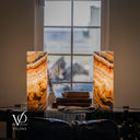 Illuminated Aqua Onyx lamp pair with charcoal-edged upper ribbons rising toward the center and broad amber and cream layers.