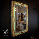 Decorative mirror with a natural wood frame on a dark wall, featuring the brand 'Vilona'.