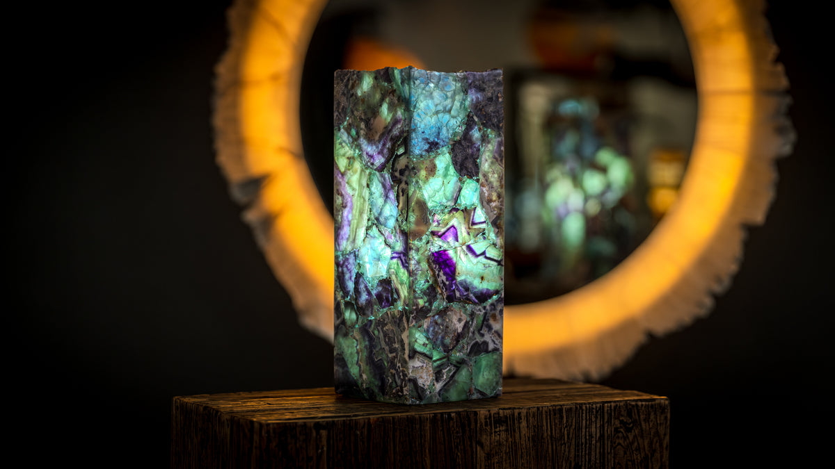 Illuminated fluorite tower lamp displayed with a glowing natural stone mirror