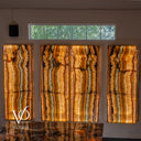 Four illuminated Exotic Aqua Onyx wall panels displayed inside the Vilona Onyx gallery
