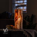 Illuminated Tangerine Onyx table lamp glowing with natural orange, amber, cream, and golden stone patterns