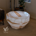 Angled view of the illuminated octagonal onyx coffee table showing its polished top and geometric stone faces.