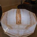 Elevated view of the White Ice Onyx table’s eight-sided top with a central amber ribbon and luminous white banding.