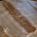 Close-up of the unlit White Ice Onyx tabletop showing intricate caramel, cream, and pale gray mineral layers.