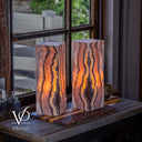 Matching Rosa Onyx lamps lit from within to reveal dramatic vertical mineral patterns and warm translucency