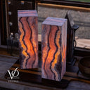 Illuminated Rosa Onyx table lamp pair glowing with rose, cream, amber, and burgundy natural banding