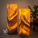 Illuminated square onyx floor lamps showing vivid amber translucency and sweeping brown banding