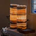 Illuminated Honeycomb Onyx table lamp pair glowing with honey, cream, caramel, and dark brown natural banding