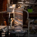 Handcrafted Sahara Onyx lamp lit from within to reveal layered horizontal mineral movement