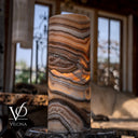 Natural Sahara Onyx table lamp illuminated to showcase its translucency and contrasting dark mineral lines